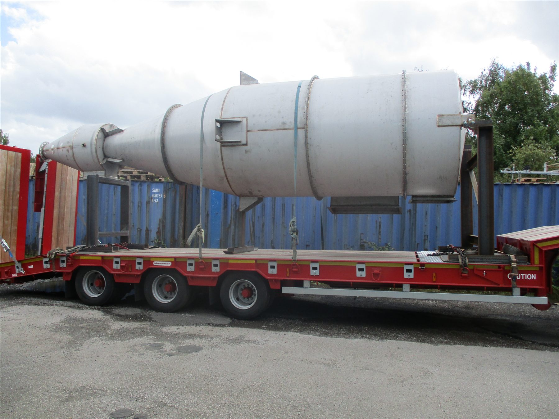Stainless steel cyclone vessel strapped to a low-loader trailer for delivery